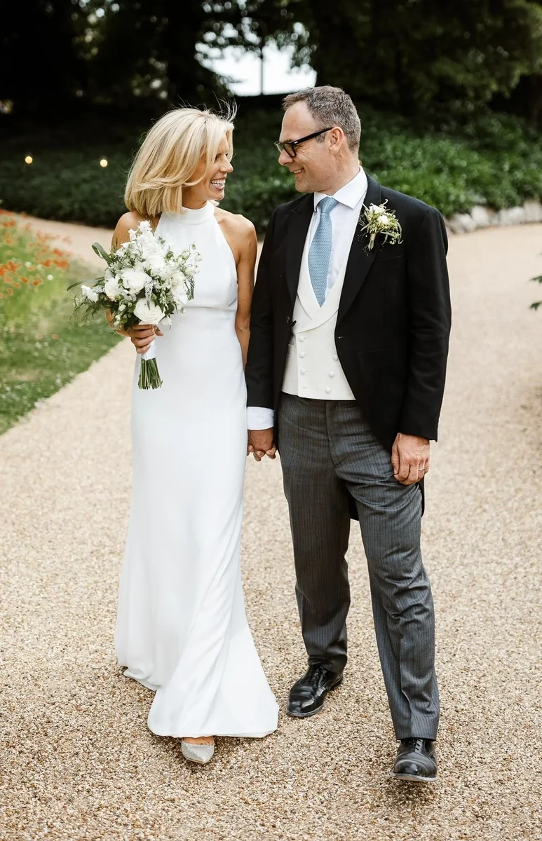 Bride and groom walking together with a white bridal bouquet