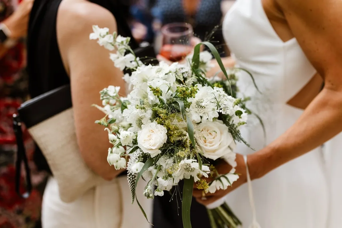 Bride holding a loose white and green bouquet