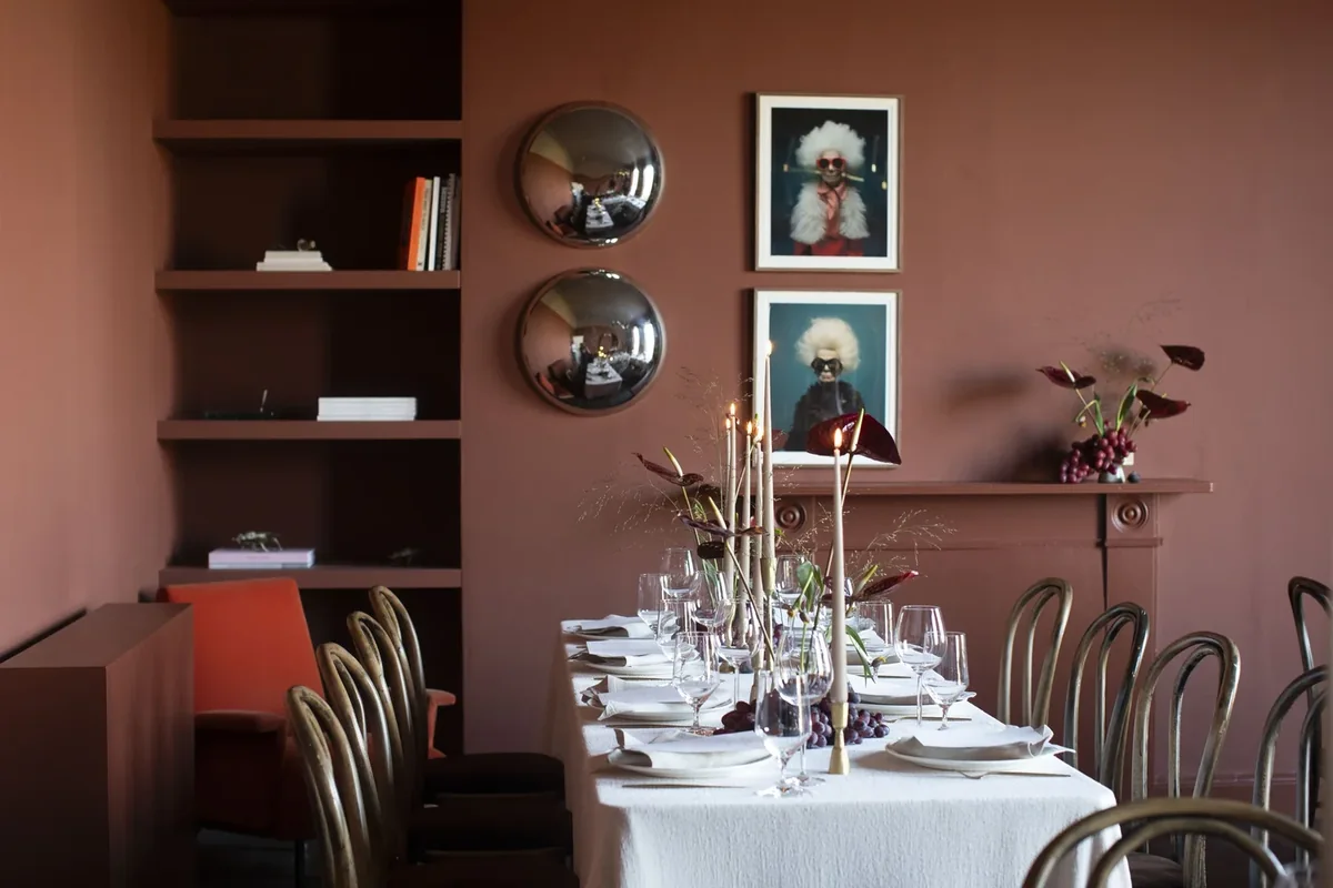 Private dining table arranged in a warm pink room