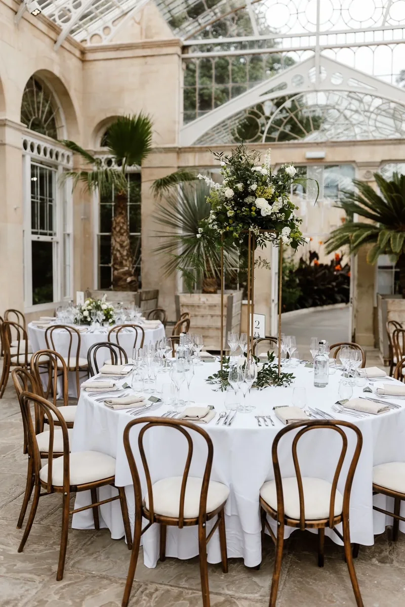Glasshouse wedding table dressed with white and green flowers