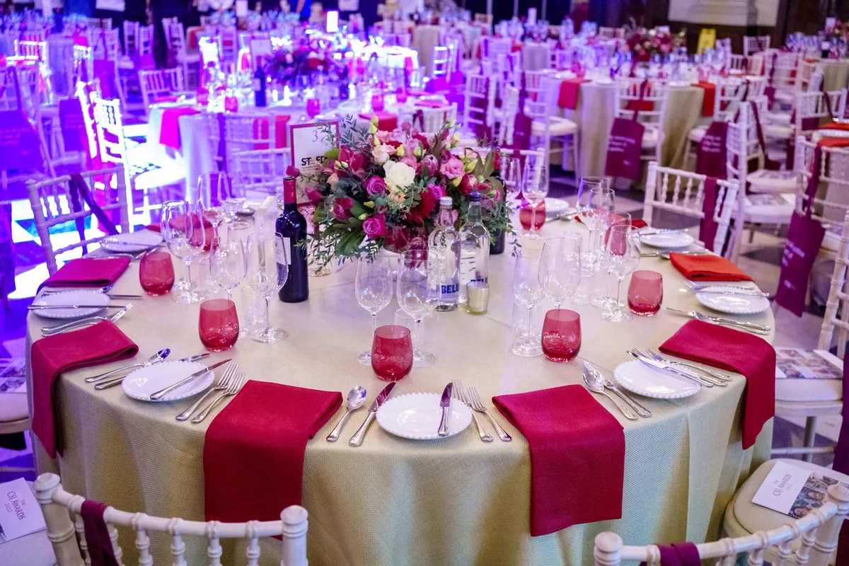 Awards dinner tables dressed in pink linen and rose centrepieces