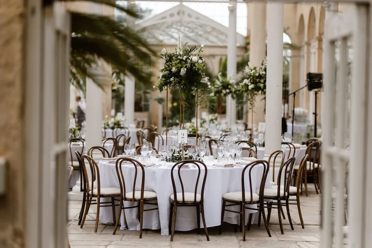 Round wedding tables dressed with white and green flowers
