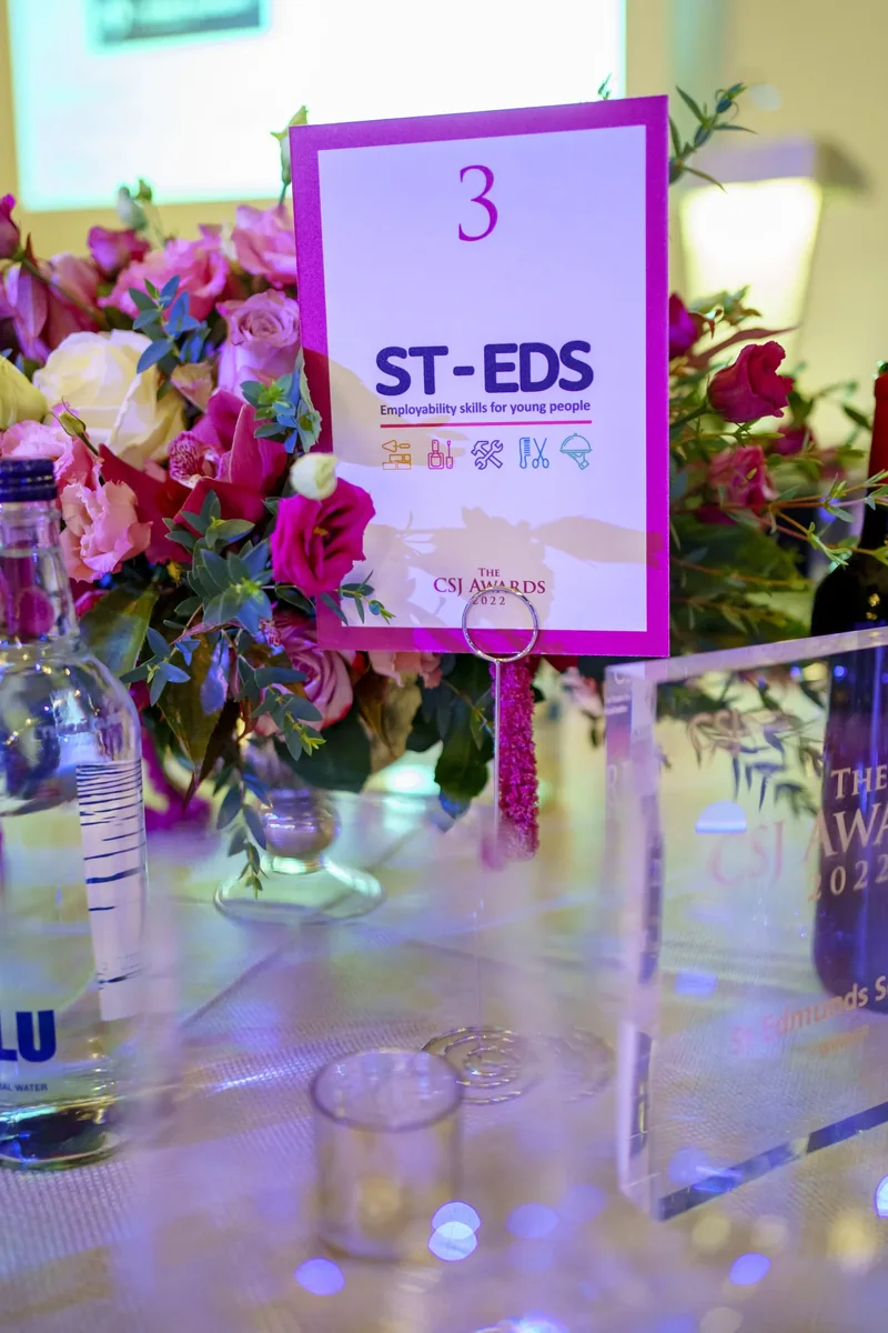 Pink event flowers beside a table number