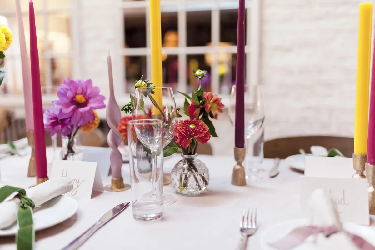 Colourful flowers and bright taper candles on a celebration table