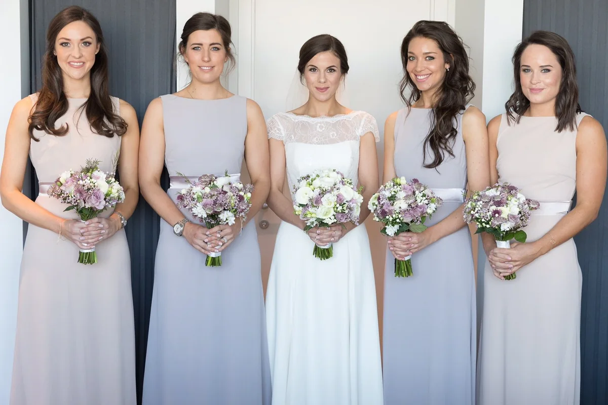 Bride and bridesmaids holding pastel bouquets