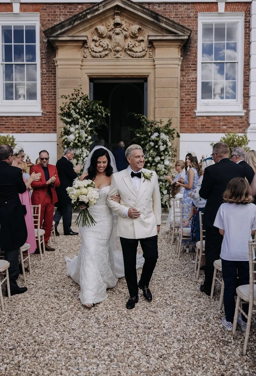 Newlyweds leaving an outdoor ceremony through their guests