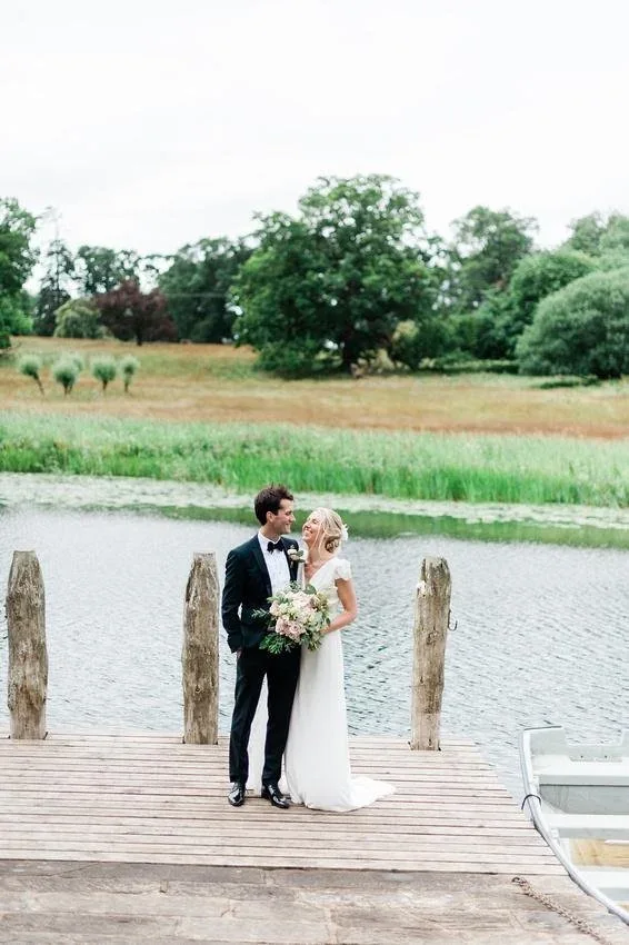 Newlyweds beside a lake at their country wedding