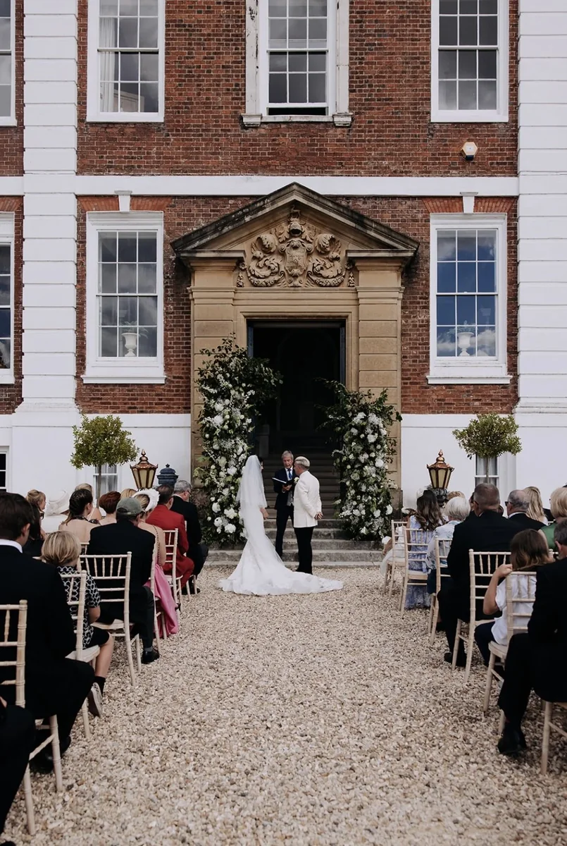 Country house wedding ceremony with flowers around the entrance