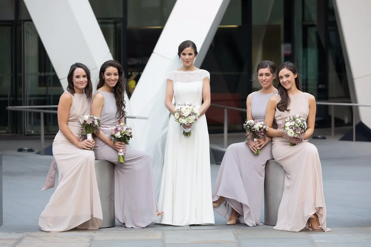 Bride and bridesmaids holding soft pastel bouquets