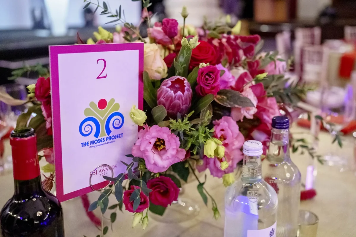 Pink table flowers and event number at an awards dinner