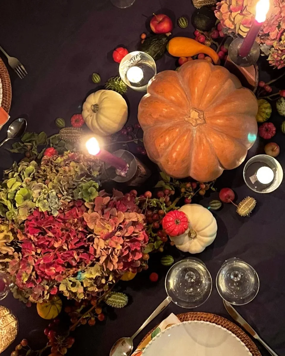 Autumn event table styled with pumpkins, flowers and candlelight