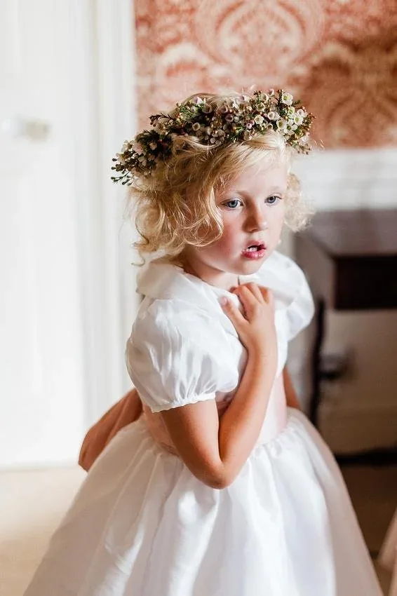 Young flower girl wearing a delicate flower crown