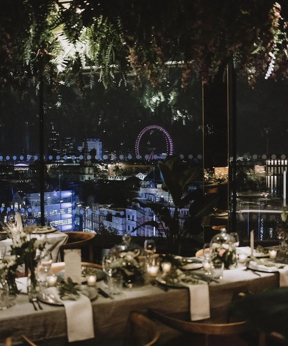 Dining tables beneath a dramatic suspended flower installation