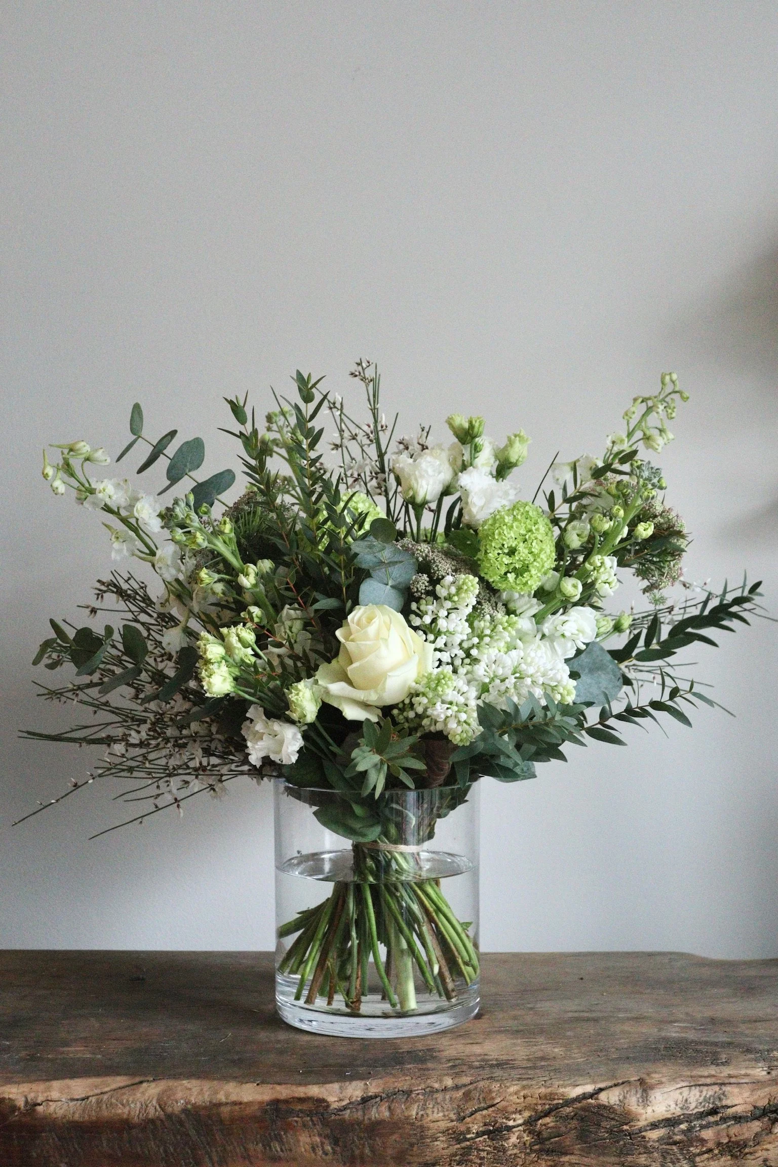 White seasonal bouquet resting on a studio worktop