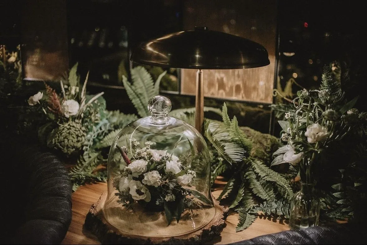 Low white and green table flowers at an evening event